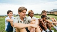 Group of Gen Z boys having fun outdoors in nature without smart phones, featured boy with acne