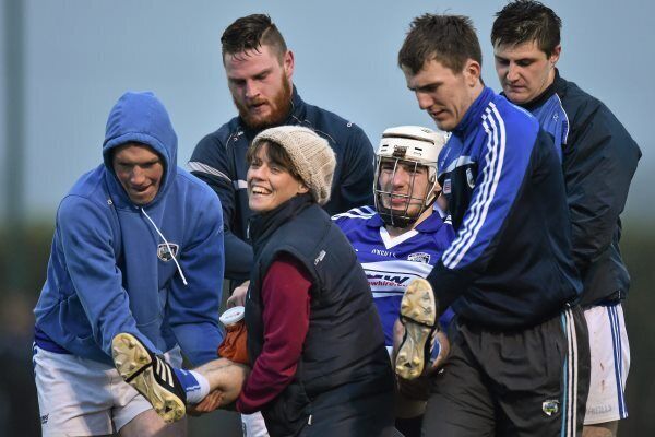 Ben Conroy, Laois, is helped off the field by team-mates, from left, Padraig Lalor, Neil Foyle, Ciaran Collier, Ryan Mullaney, and team Doctor Sharon McDonnell, after a knee injury during the game at Kelly Heywood Community School. Photo: Matt Browne / SPORTSFILE
