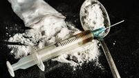 A drug syringe and a spoon with cooked heroin