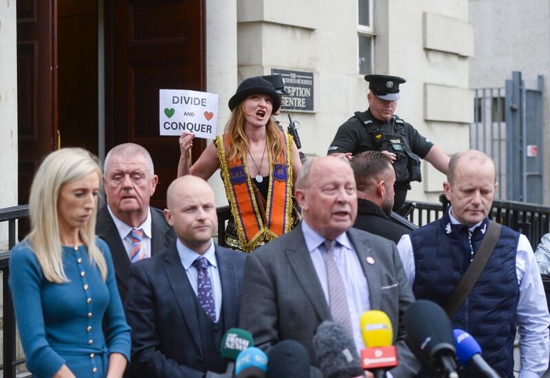 Representatives of the Orange Order are heckled by artist Clodagh Byrne as they leave the High Court in Belfast following a reserved judgment. Picture: Mark Marlow/PA