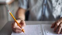 Midsection of male student studying in classroom