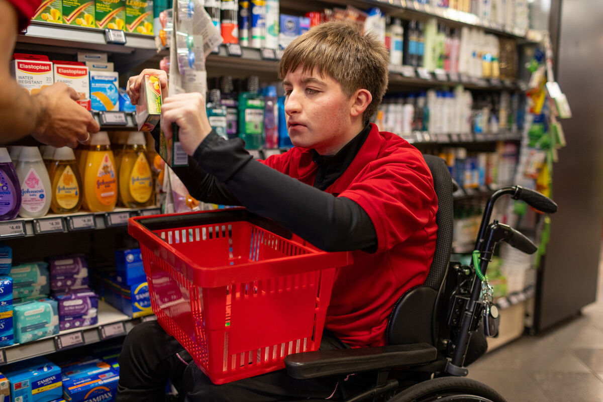 Tomás Lynch stacking shelves at his father Micheál’s Spar shop with his 'buddy' and fellow employee Dara Rohan. Picture: Neil Michael. Tomás Lynch stacking shelves at his father Micheál’s Spar shop with his 'buddy' and fellow employee Dara Rohan. Picture: Neil Michael.