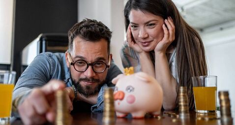Young couple admiring their savings in piggy bank