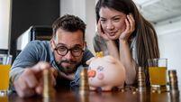 Young couple admiring their savings in piggy bank