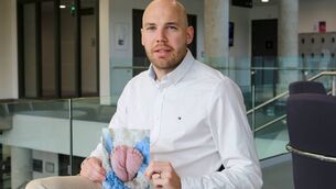 <p>Lewis King, whose son Freddie died at 31 weeks’ gestation, pictured with a photograph of Freddie’s feet. Picture: Paul Molloy</p>