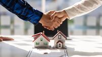 Real estate agents shake hands after the signing of the contract agreement is complete.