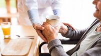 Unrecognizable health visitor and a senior woman during home visit.