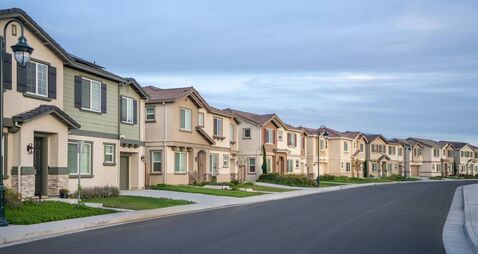 Suburban residential street with row houses and new construction homes