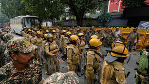 Security personnel in riot gear stand guard outside the Election Commission office in New Delhi ahead of a planned protest (Manish Swarup/AP) Security personnel in riot gear stand guard outside the Election Commission office in New Delhi ahead of a planned protest (Manish Swarup/AP)