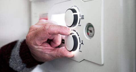 A pensioner adjusting the temperature control on his combi boiler. Redcar, UK. 26/5/2021. Photograph: Stuart Boulton.
