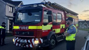 <p>Firefighters and gardaí at the scene of the fire which claimed the lives of two adults and two children in the Birchwood estate in Waterford City. Picture: Micheál Ó Scannáil/PA</p>