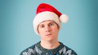 Man With Disgusted Look Wearing Santa Hat and Ugly Sweater
