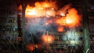 A damaged multi-storey residential building is seen on fire after a Russian missile strike on Kyiv, Ukraine (Evgeniy Maloletka/AP)