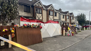 <p>Floral tributes outside the scene of suspected arson attack at a house in Birchwood, Waterford, which claimed the lives of two adults and two children. Picture: PA</p>
