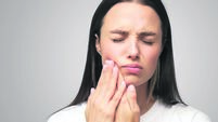 Miserable woman experiencing severe toothache, pressing palm to cheek, closing eyes because of pain