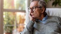 Senior man looking out of window at home