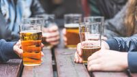 Hands holding glasses with beer on a table in London