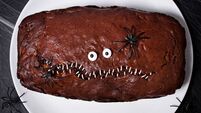 Halloween food. Scary chocolate cake with eyes and spiders on a plate on a dark background. Terrible food. Thematic food. Hallow