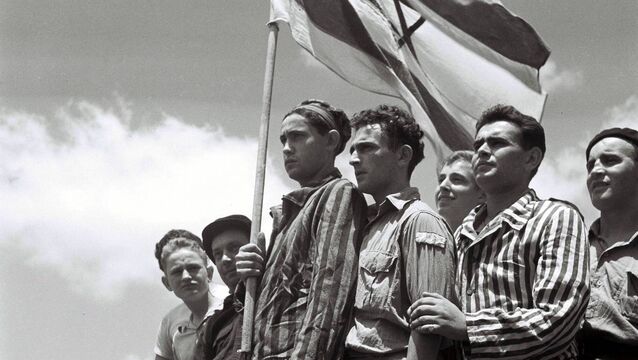 <p>HAIFA, MANDATE PALESTINE - JULY 15, 1945: Jewish survivors of the Buchenwald Nazi concentration camp, some still in their camp clothing, stand proudly on the deck of the refugee immigration ship Mataroa July 15, 1945 at Haifa port, during the British Mandate of Palestine, in what would later become the State of Israel. (Photo by Zoltan Kluger/GPO via Getty Images)</p>