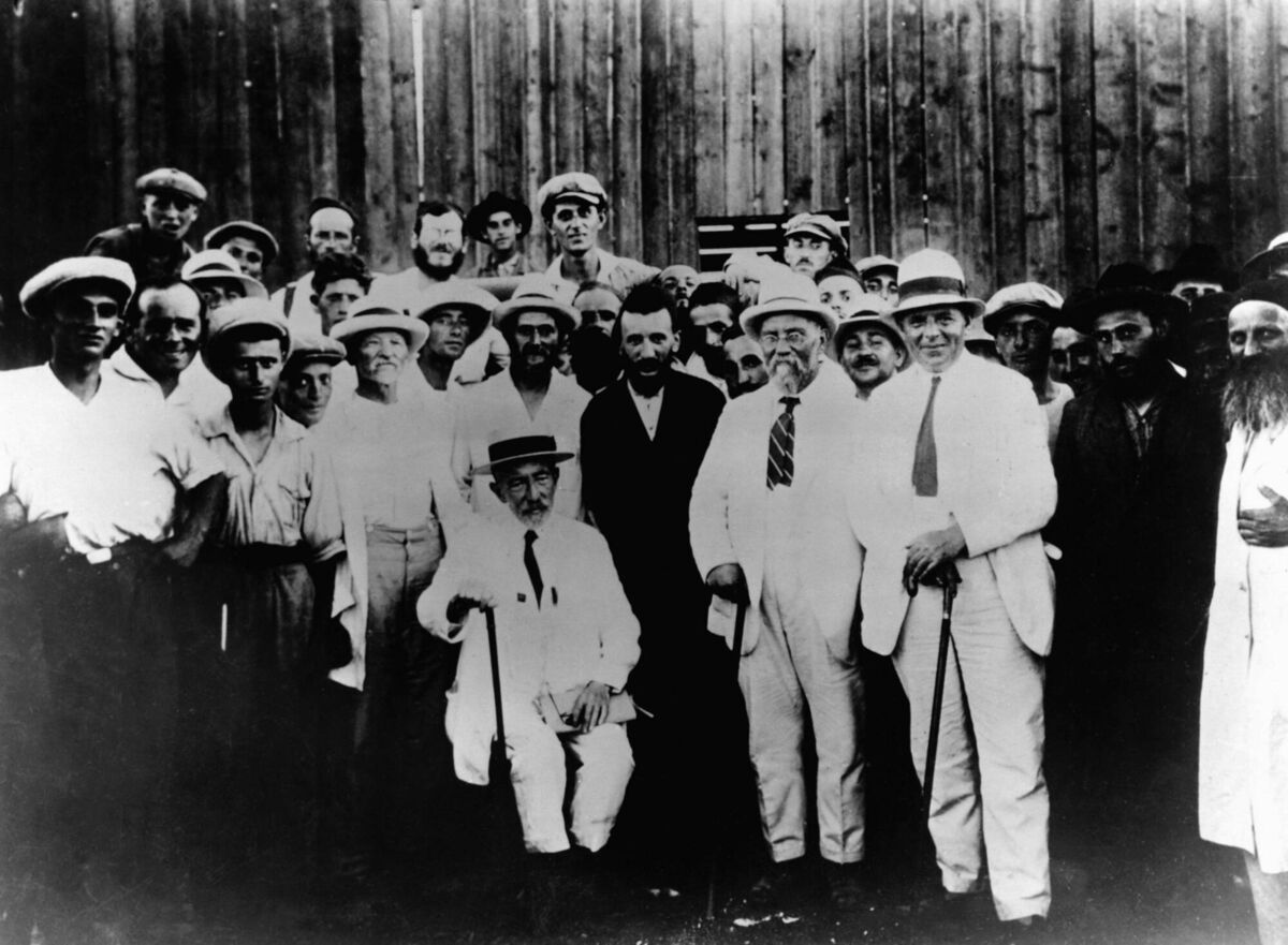 Writer and Jewish philosopher Achad Ha'am sits next to Rabbi Yabloner, right, head of the Nachalat Yaakov Hasidic colony in Palestine, while visitors and others colony members gather around them. (Photo by © Hulton-Deutsch Collection/CORBIS/Corbis via Getty Images)
