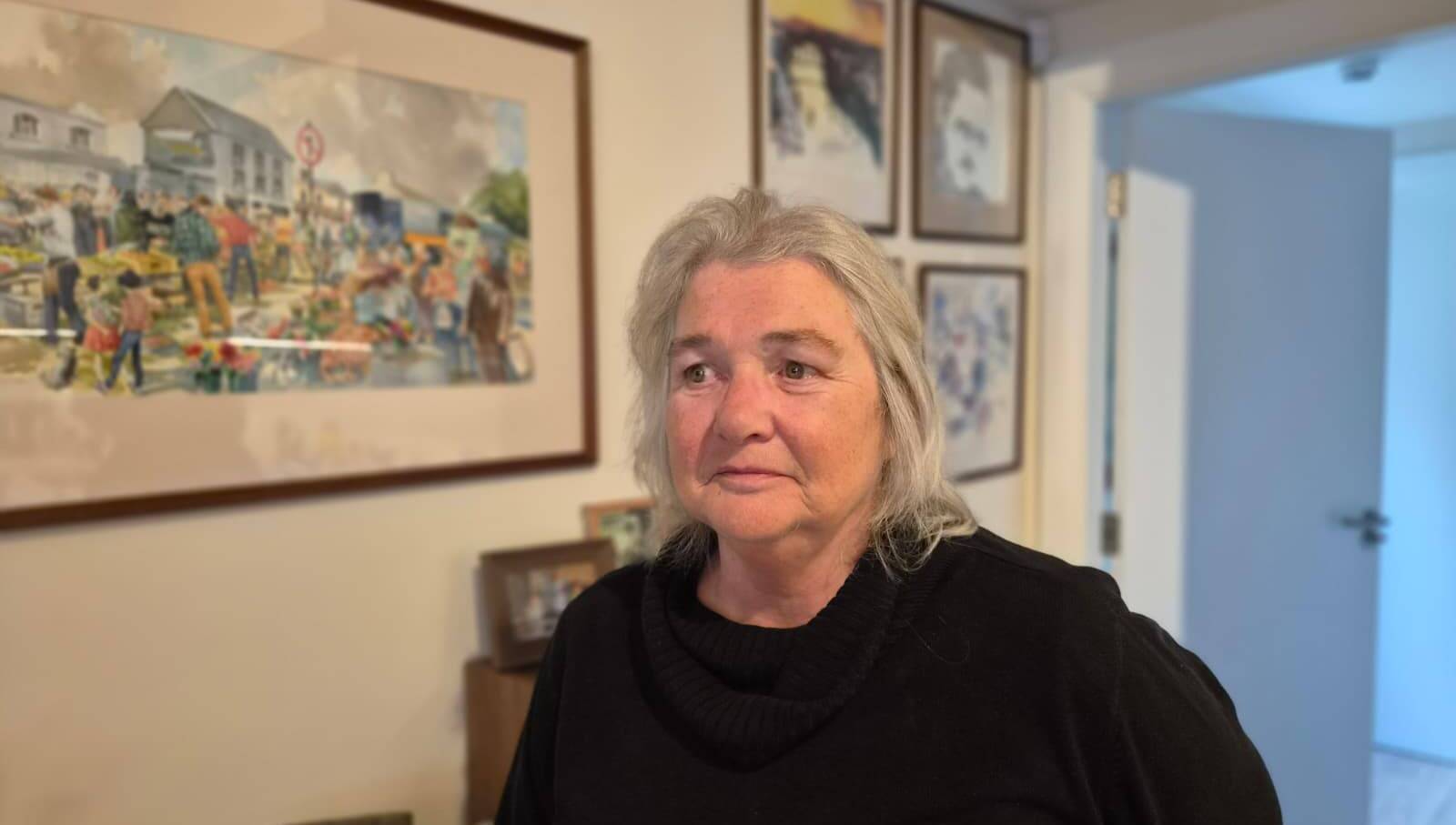 Mary Jane Farrer, from Galway, poses in front of her father's paintings.