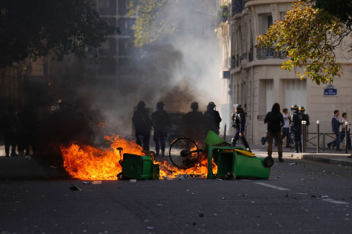 Policemen stand in front of burning garbage as they face students during a protest against under-resourced schools, in Paris. Picture from October 2. Picture: AP Photo/Aurelien Morissard