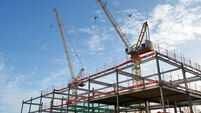Steel frame and two cranes on a UK construction site