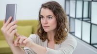 Serious Young Woman Taking Selfie at Home