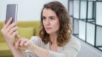 Serious Young Woman Taking Selfie at Home