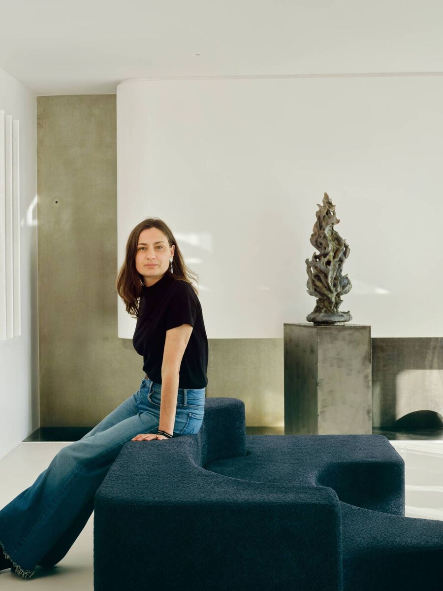 Designer Sandrine Sarah Faivre perched in an interior she created at Villa Alta. Picture: Clément Vayssieres
