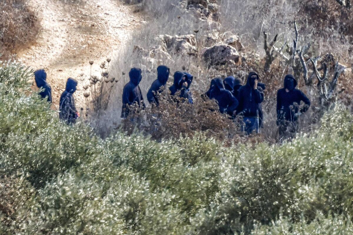 Israeli settlers are seen near farmers as they pick olives in Turmus Ayya, northeast of Ramallah in the Israeli-occupied West Bank. Picture: Zain Jaafar/AFP via Getty Images Israeli settlers are seen near farmers as they pick olives in Turmus Ayya, northeast of Ramallah in the Israeli-occupied West Bank. Picture: Zain Jaafar/AFP via Getty Images
