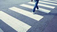 Man in jeans walking across a zebra crossing