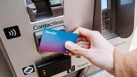 London, United Kingdom - 14 March, 2025: Hand holding Revolut Visa bank card tapping contactless payment terminal on automated t