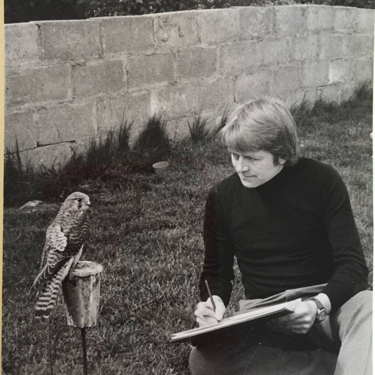 An archive photo of Don Conroy sketching a bird up close