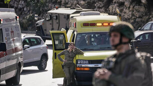 Israeli soldiers and emergency personnel gather near ambulances following a shooting attack carried out by Palestinian gunmen at a junction near Hebron (Mahmoud Illean/AP) Israeli soldiers and emergency personnel gather near ambulances following a shooting attack carried out by Palestinian gunmen at a junction near Hebron (Mahmoud Illean/AP)