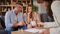 Pregnant couple discussing family life insurance with consultant