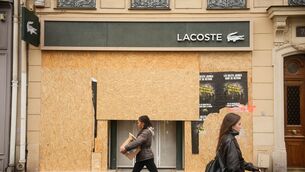 Passersby walk past a boarded-up store in Paris (Teresa Suarez/AP) Passersby walk past a boarded-up store in Paris (Teresa Suarez/AP)