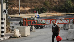 Palestinians cross on foot past a military gate closed to vehicles during an Israeli army operation in Hebron (Mahmoud Illean/AP) Palestinians cross on foot past a military gate closed to vehicles during an Israeli army operation in Hebron (Mahmoud Illean/AP)