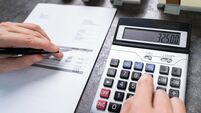 Businessman Calculating Tax By Small And Big House Models