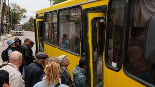 People board a bus during a local ceasefire linked to efforts to evacuate residents of Oleshky in Ukraine (Evgeniy Maloletka/AP)