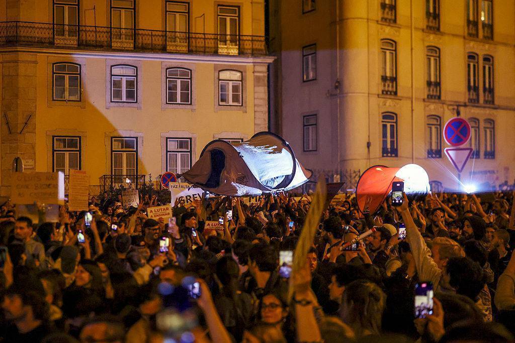 People hold up tents during a protest against the housing shortage, soaring rents, and low wages in front of the Portuguese Parliament in Lisbon. Picture: Patricia D Melo Moreira/AFP via Getty