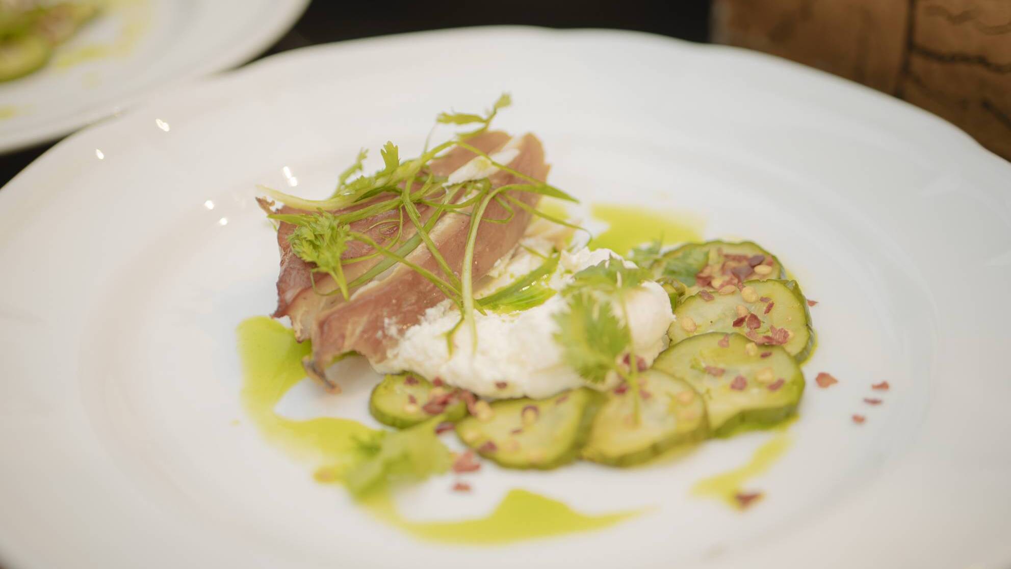 Hot smoked fish labneh with cucumber pickle and scallion oil.
