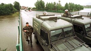 <p>Soldiers cordon off the Lower Ormeau Road in Belfast in the 1990s ahead of a Loyalist parade (PA)</p>