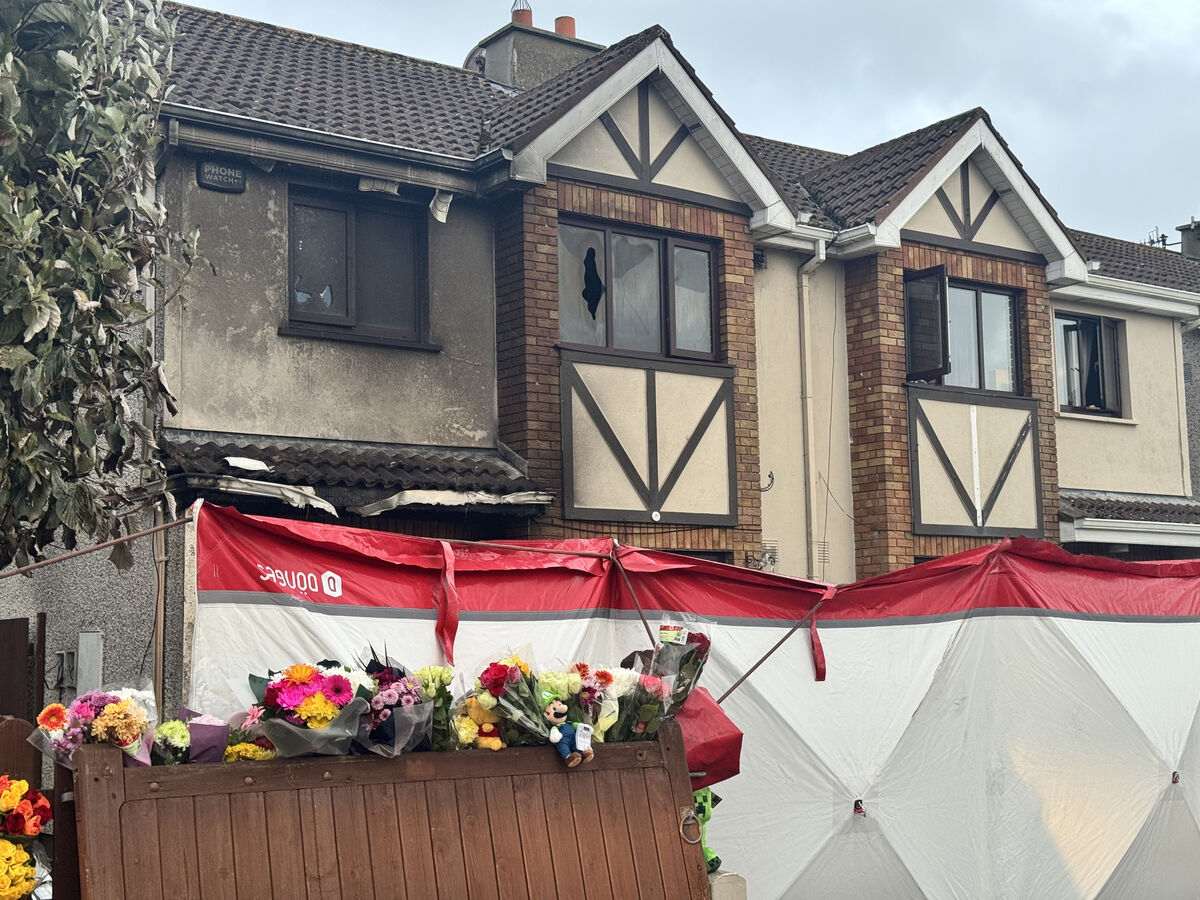 Floral tributes outside the home of the English family in Birchwood, Waterford City after the fire that claimed four lives and left two children seriously injured. Picture: PA