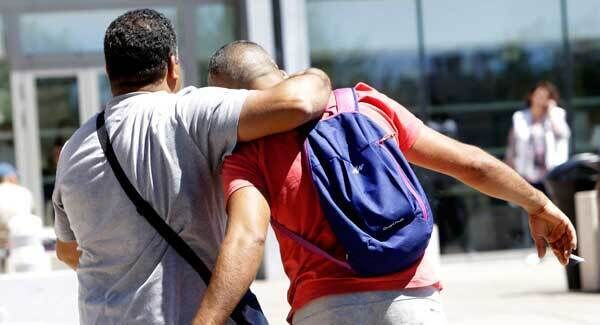 Tahar Mejri, right, reacts after learning the death of a relative, outside the Pasteur hospital in Nice. Pic: AP