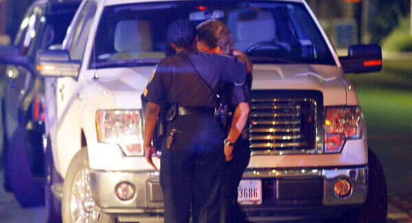 Two law enforcement officers console each other outside the emergency room of Baylor University Medical Center in Dallas. AP Photo/Tony Gutierrez.