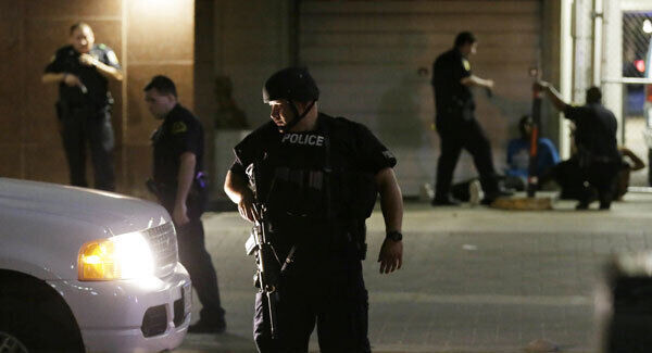 Dallas police detain a driver after several police officers were shot in downtown Dallas. Picture: AP Photo/LM Otero.