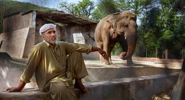 Caretaker Mohammad Jalal talks to the Associated Press next to 'Kaavan' at Marghazar Zoo in Islamabad, Pakistan.