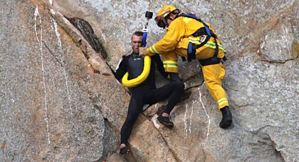 In this photo provided by Bob Isenberg, Michael Banks is rescued after being stranded on a ledge off the ground on Morro Rock, a landmark in Morro Bay, California. Pictures: Bob Isenberg / AP