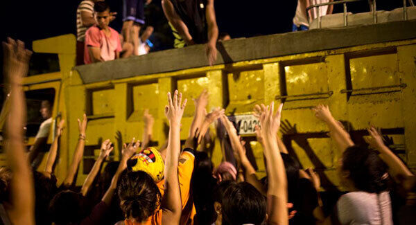 Volunteers hand out water and food from a truck to the residents of Estancia Las Palmas. (AP photo)